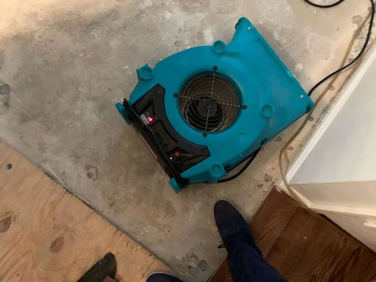 Air mover drying subfloor during Commercial Water Damage Restoration in Christiansburg